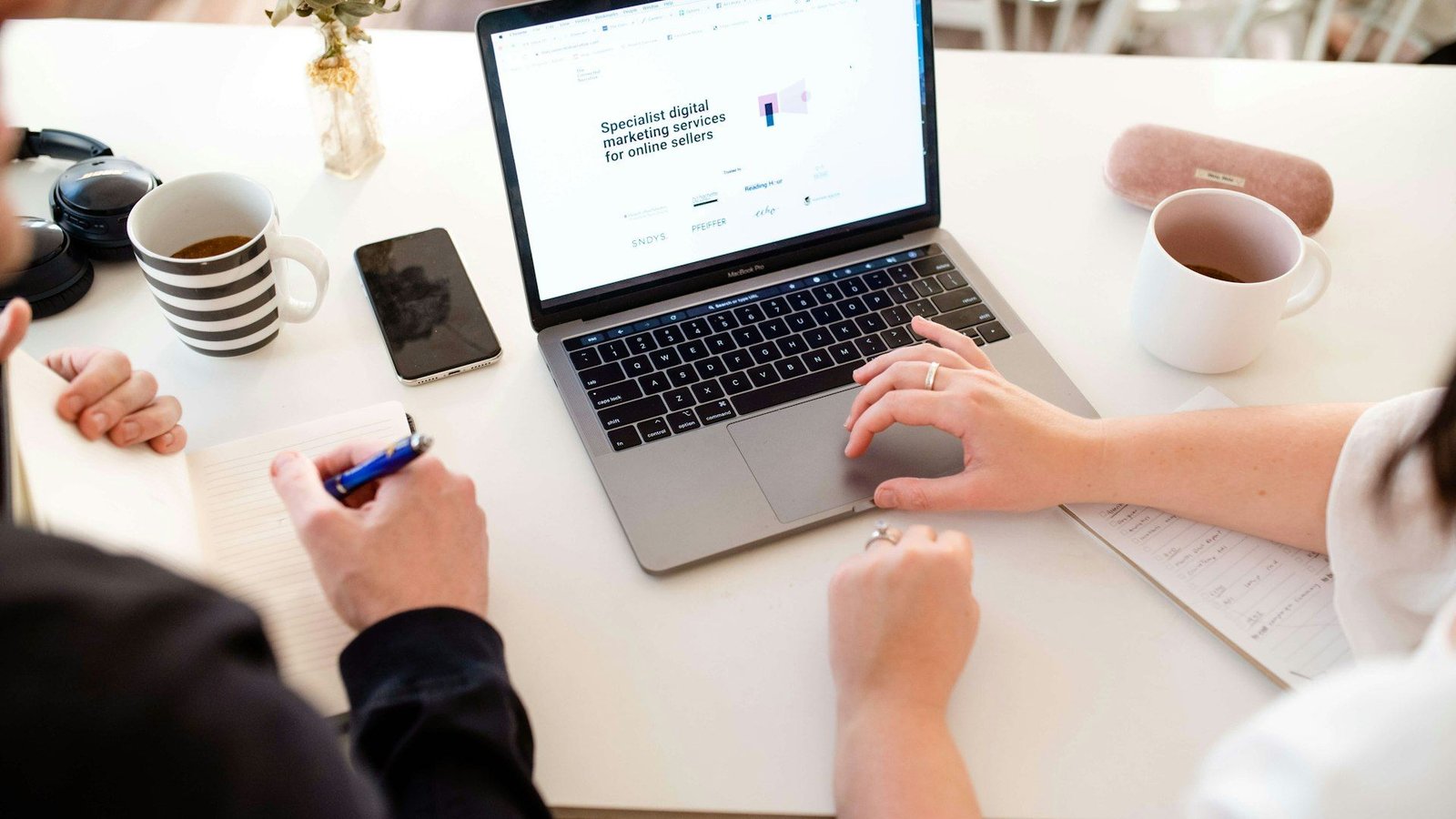 Two colleagues reviewing a plan together on a laptop