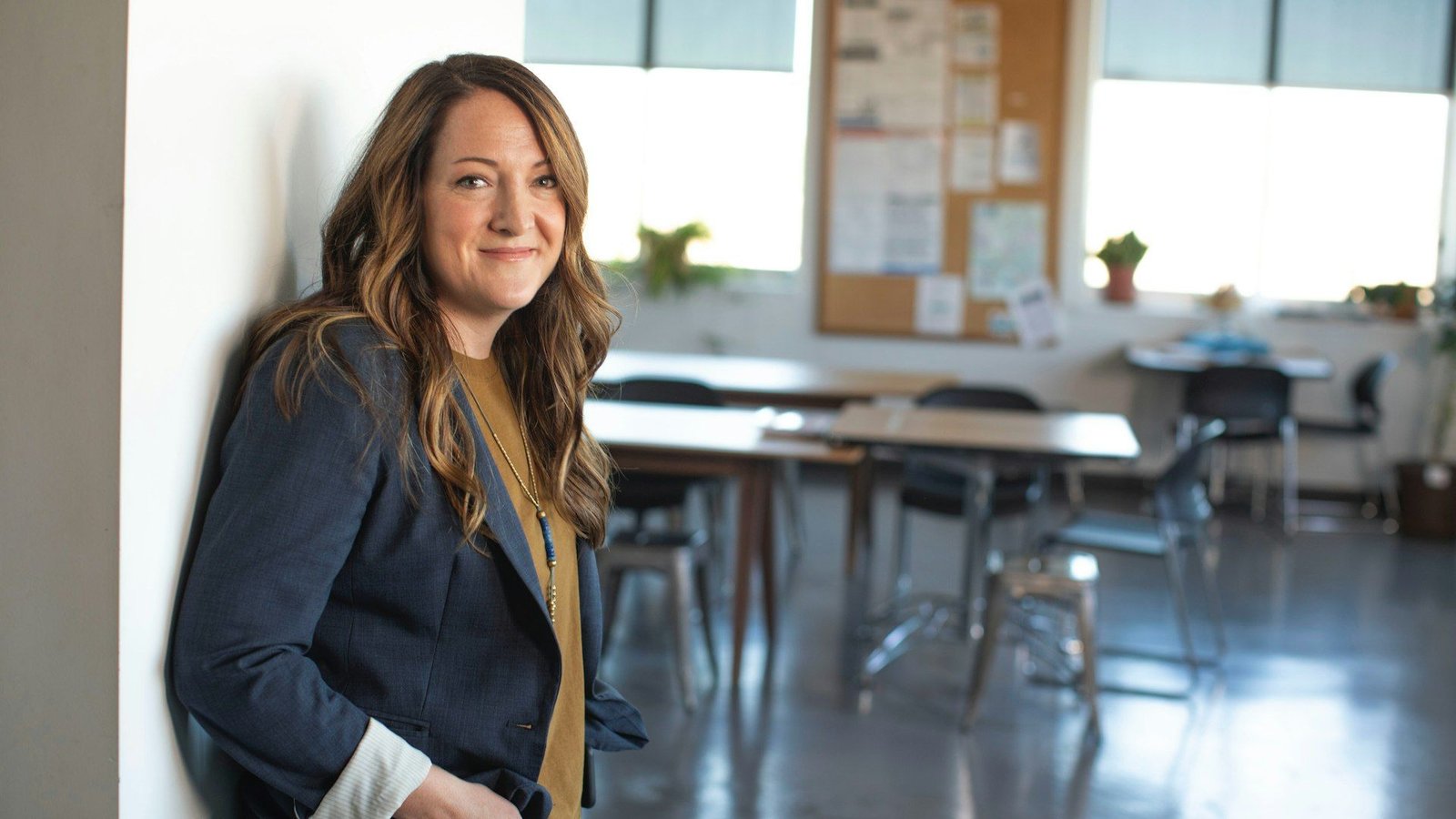 Smiling professional woman in a blue blazer in a bright office