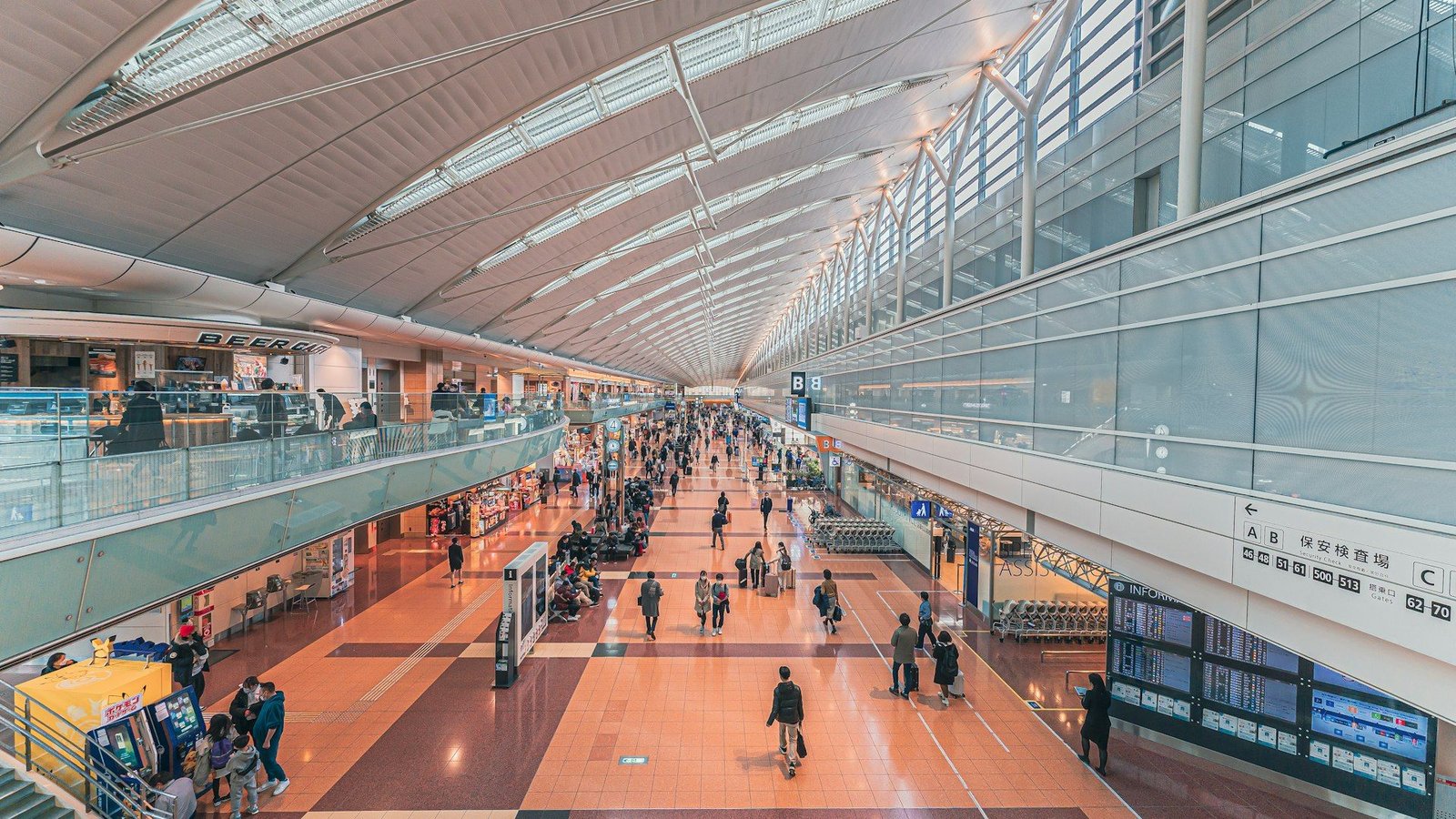 Travelers crossing a light-filled modern airport terminal